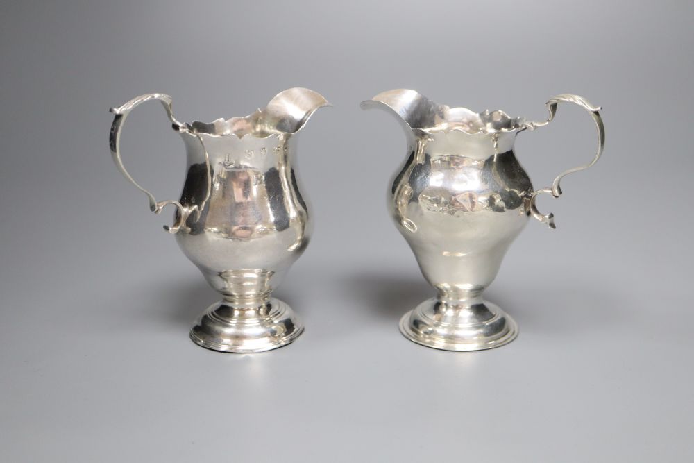 A late George II silver inverted pear shaped cream jug, Stamp & Baker, London, 1759 & one other cream jug.